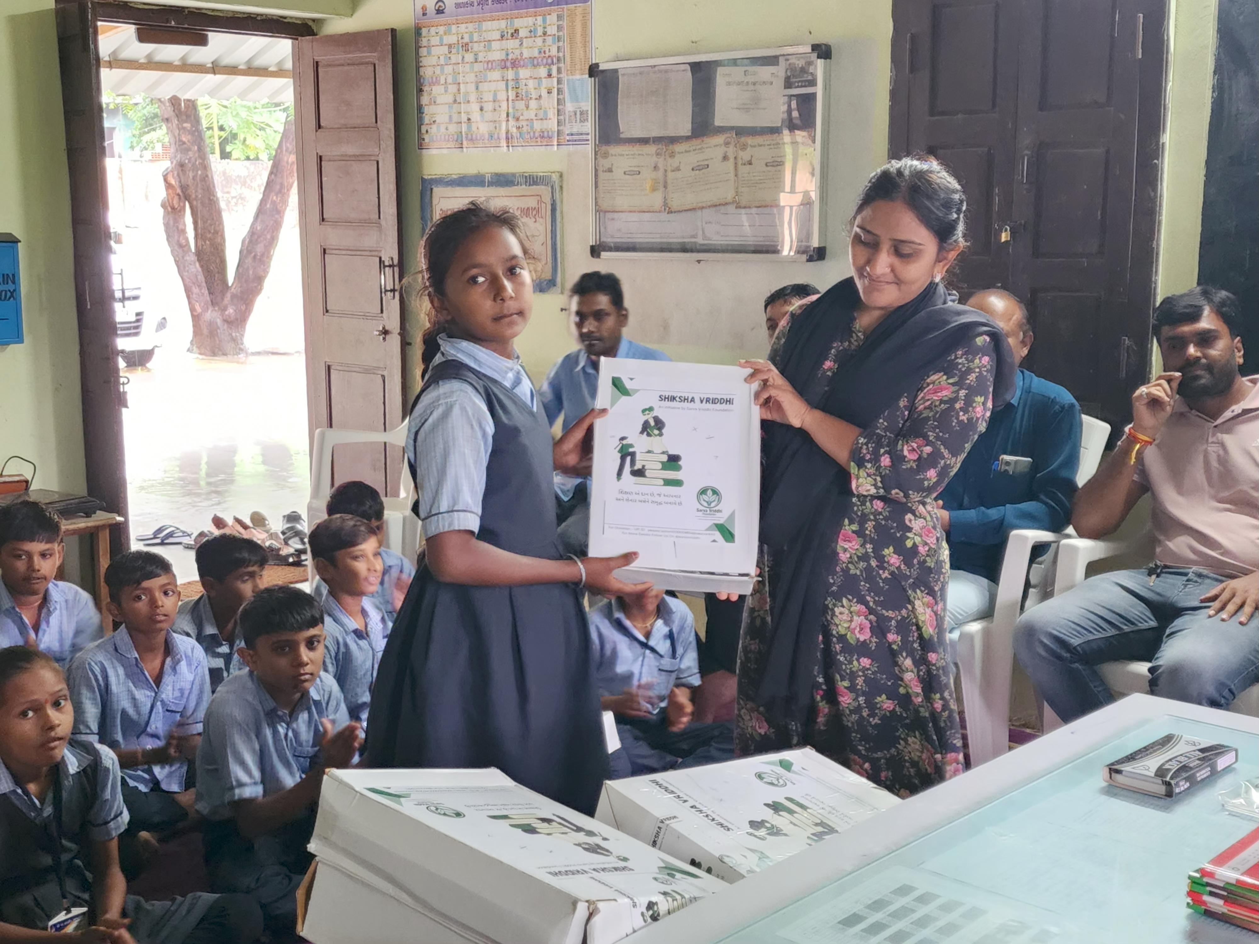 Girl receiving educational kit from team member indoors
